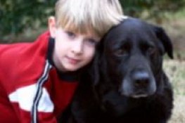 young boy with aging black dog