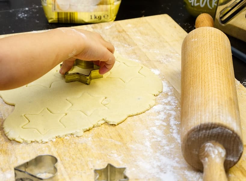 person cutting out cookie shapes