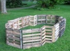 Ground-level view of dog potty area with mulch and clear boundary fence in back yard for dogs